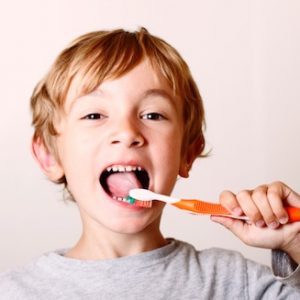 Bambino che lava i denti per prevenire le carie