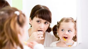 La mamma e il bambino lavano i denti